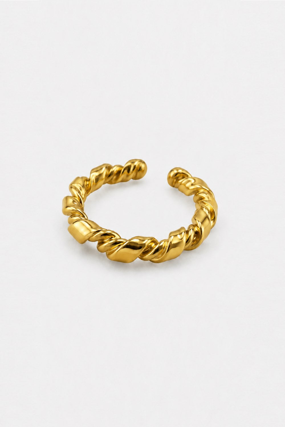 A twisted rope-style gold ring with a polished finish, displayed on a clean, light gray background.