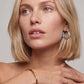 Woman with blonde hair and jewelry on a neutral background