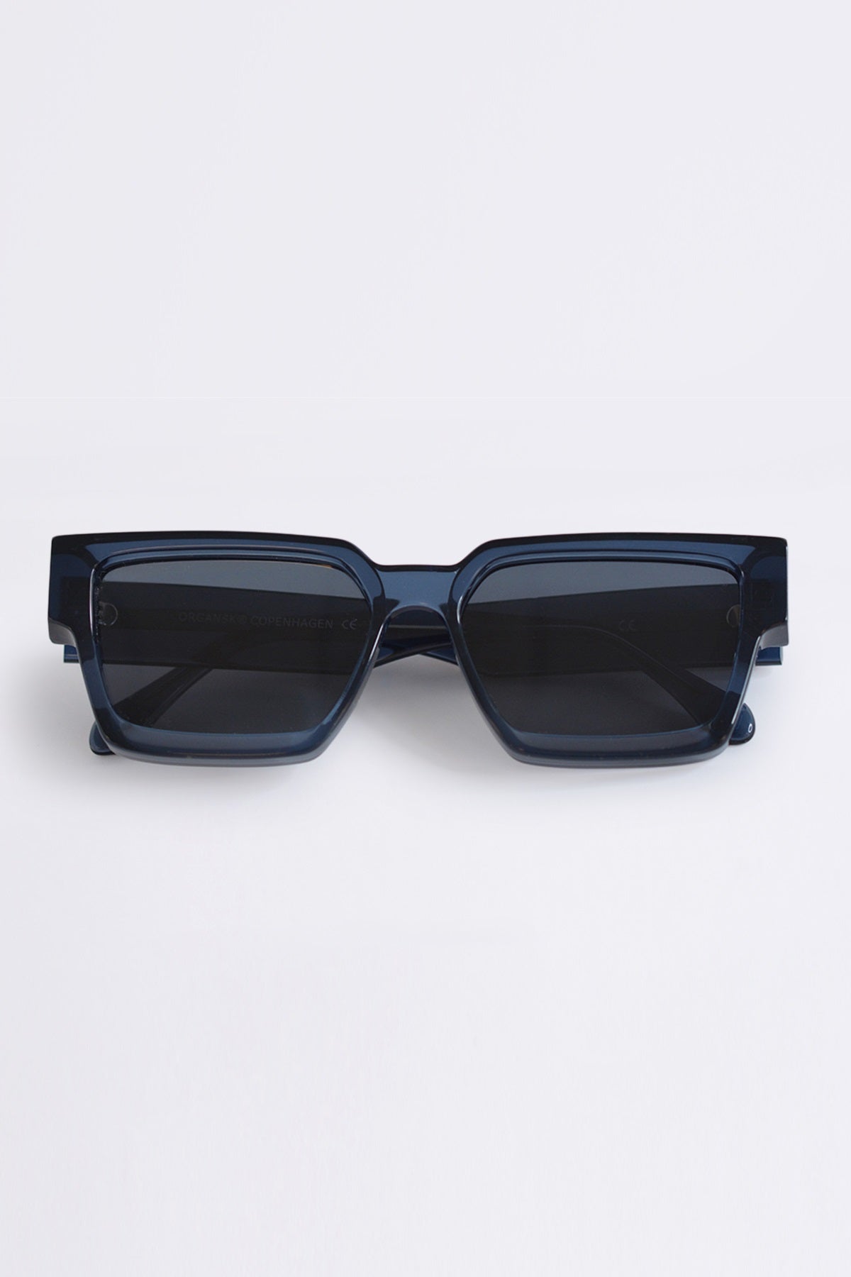 Dark blue sunglasses on a light gray background