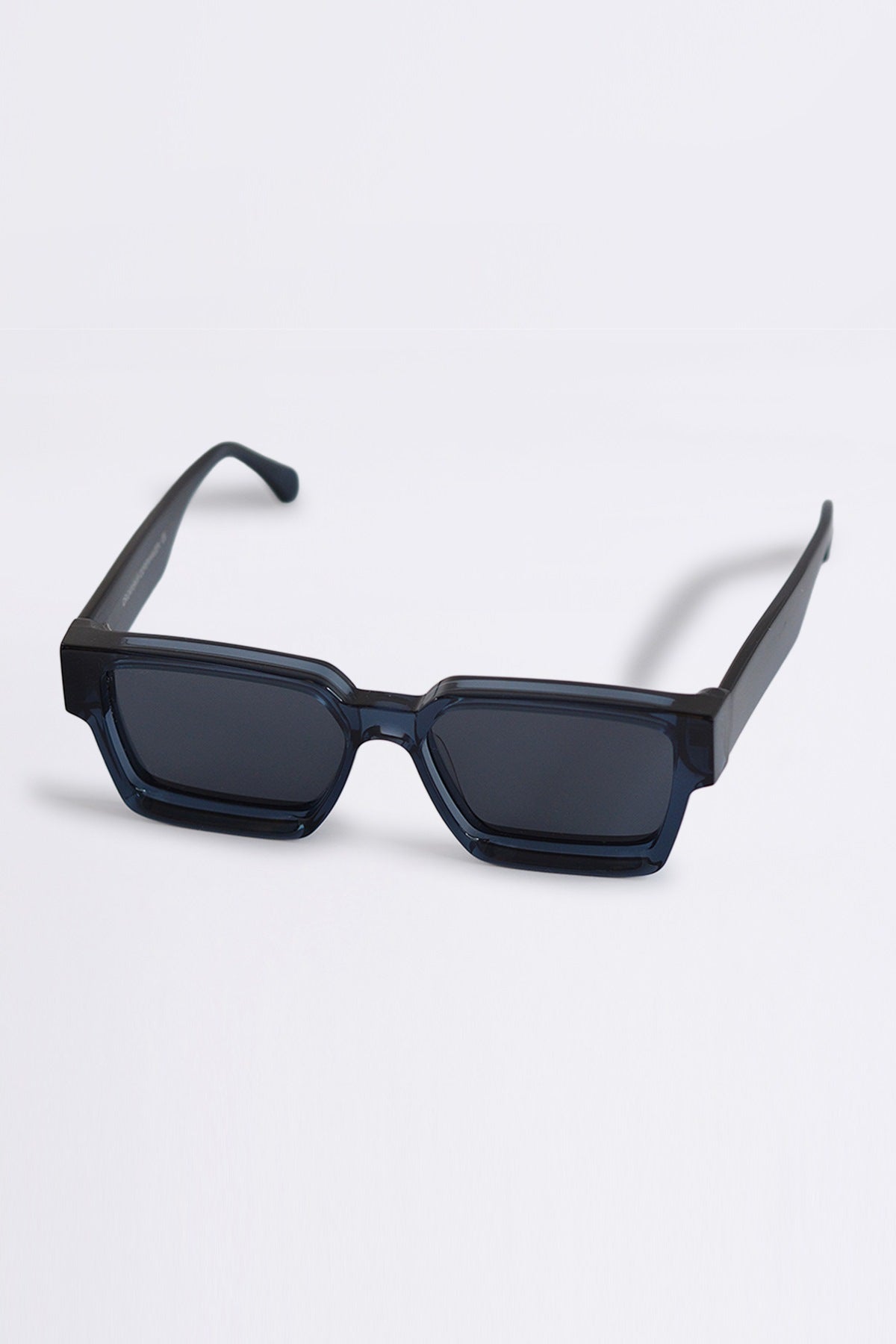 Blue sunglasses with a geometric frame on a light gray background