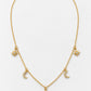 A delicate gold chain necklace featuring celestial charms, including a central sunburst pendant, two crescent moons, and two starbursts, displayed on a clean white background.