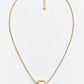 A delicate gold chain necklace with a textured cylindrical pendant, displayed on a clean white background.