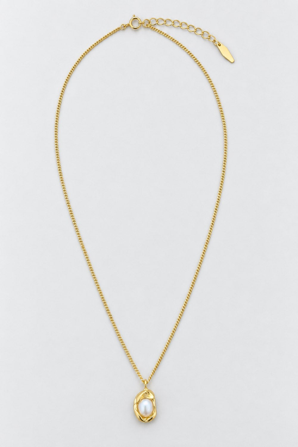 A delicate gold chain necklace with a textured gold pendant cradling a single white pearl, displayed on a clean light gray background.