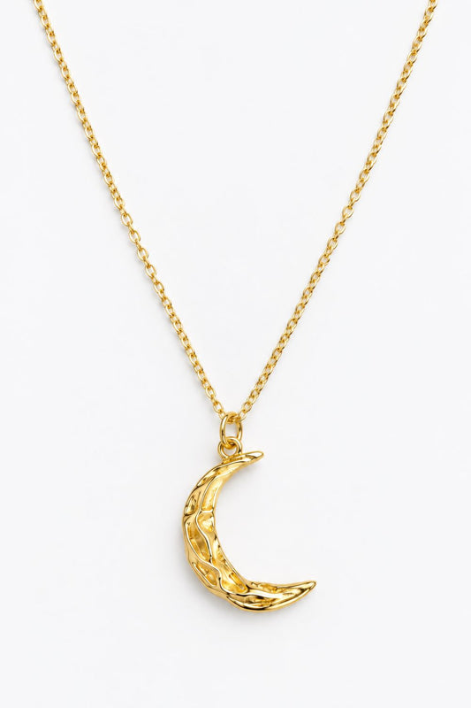 A gold chain necklace featuring a textured crescent moon pendant, displayed against a clean white background.