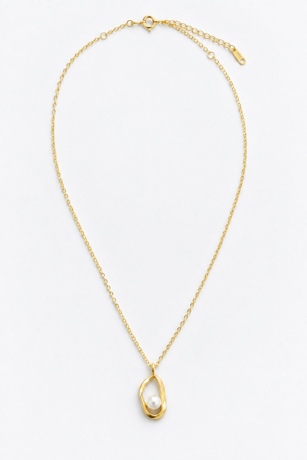 A delicate gold chain necklace featuring a unique pendant with a textured, organic gold frame enclosing a single white pearl, displayed on a clean white background.