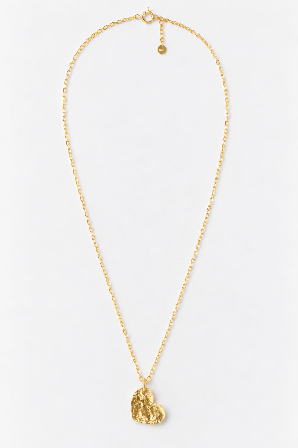 A delicate gold chain necklace featuring a small, textured gold heart-shaped pendant, displayed against a clean white background.