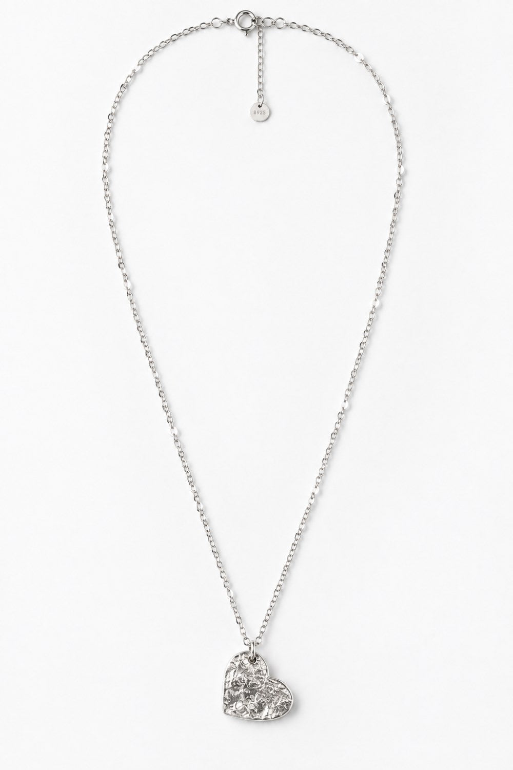 A silver-toned chain necklace with a textured, hammered heart-shaped pendant, displayed against a clean white background.