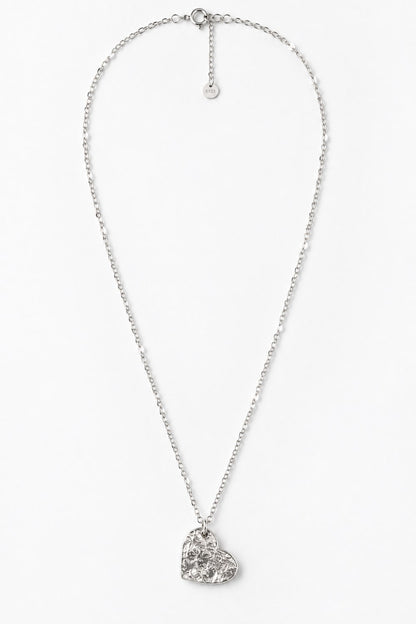 A silver-toned chain necklace with a textured, hammered heart-shaped pendant, displayed against a clean white background.
