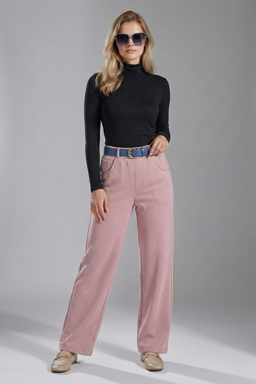 Woman wearing a black turtleneck and pink pants